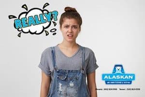 girl in overalls with thought bubble "really?" above head, Alaskan Air Conditioning and Heating logo and contact phone numbers in bottom right corner